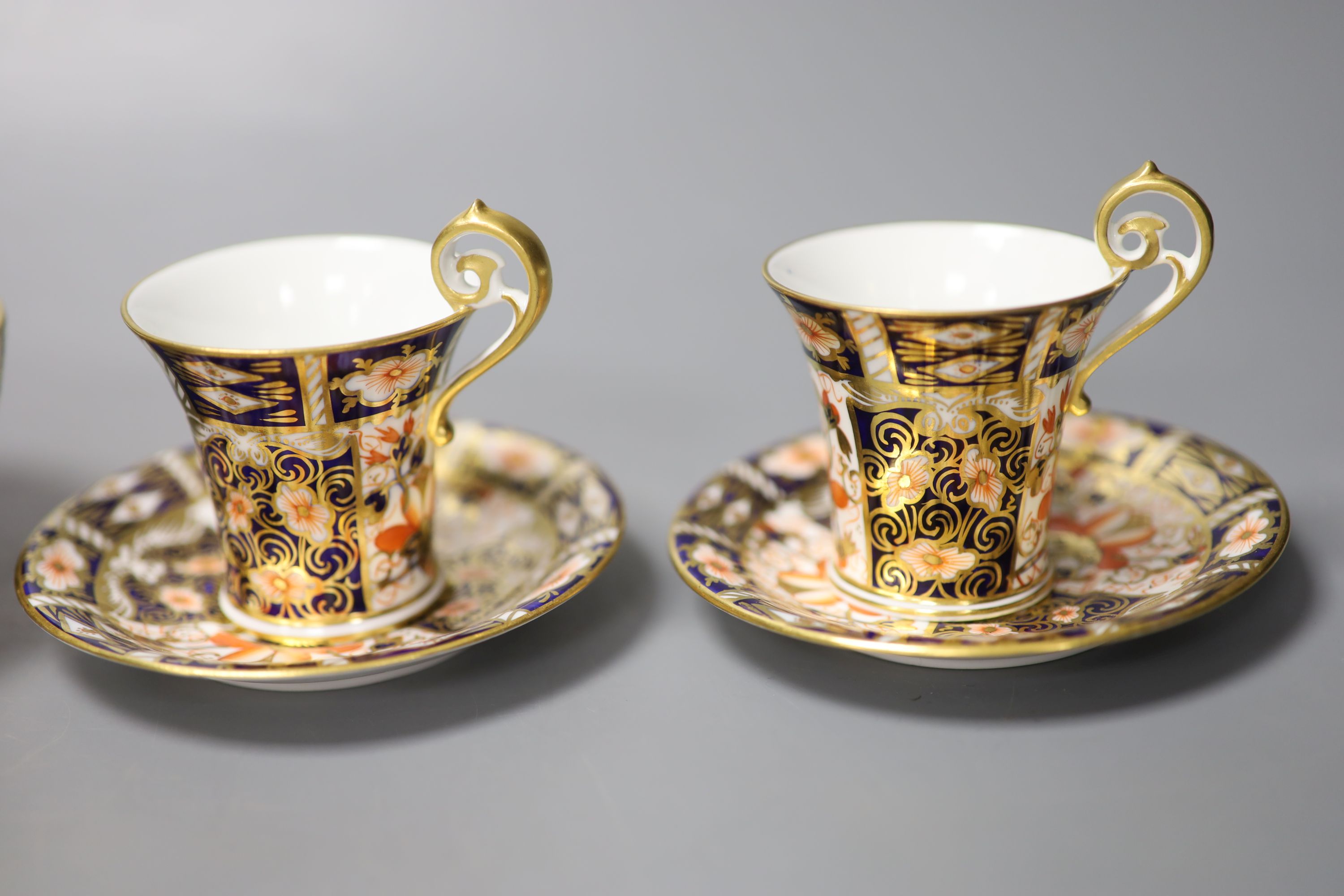 A pair of Royal Crown Derby coffee cups, imari pattern 2451, a coffee can and saucer and a sugar bowl